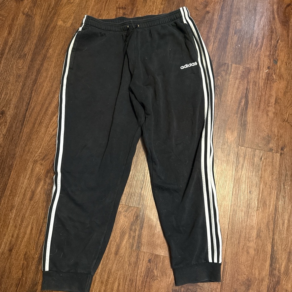 Black Adidas joggers with white stripes